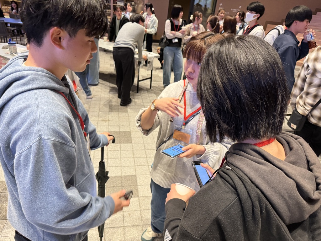 スマートフォンを見ながら、立ち話をする参加者たち